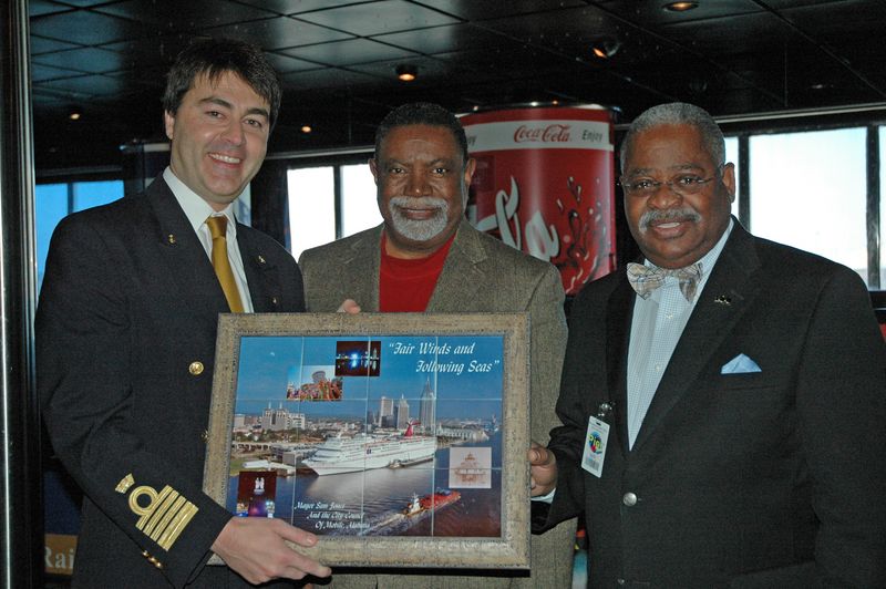 Carnival Fantasy Captain Roberto Costi (left) accepts a plaque from Mobile City Commissioner Fred Richardson (center) and Al Stokes, chief of staff of Mobile Mayor Sam Jones.    