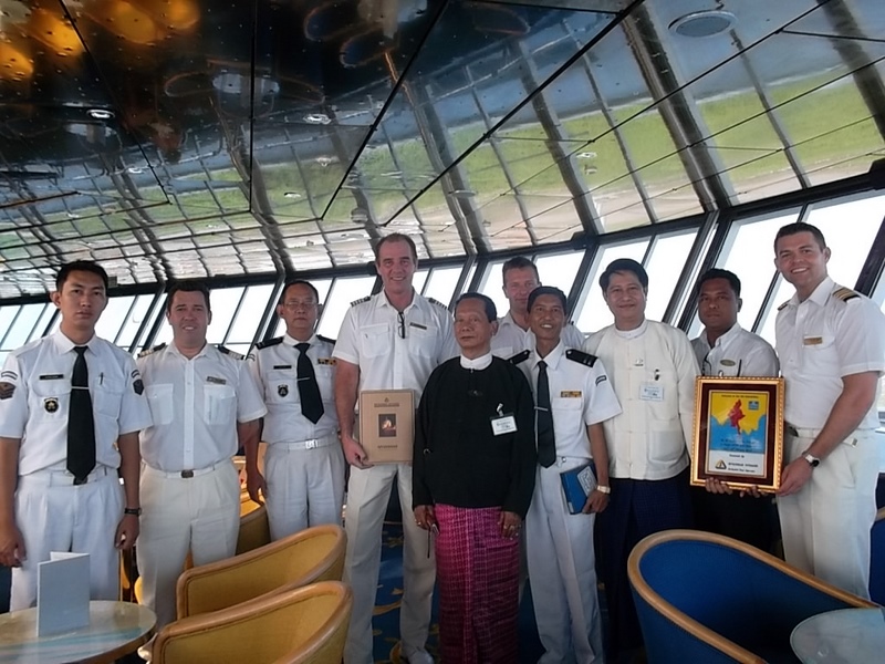 Captain Robert Bamberg, Master of Balmoral (fourth from left), Chief Officer Tony Fast (fifth from right), Hotel Manager Odd Kvamme (far right), and Food & Beverage Manager Mario De Azevedo Marques (second from left) exchange commemorative plaques with Myanmar officials to celebrate the ship’s maiden call at the port on 11th February 2014. 